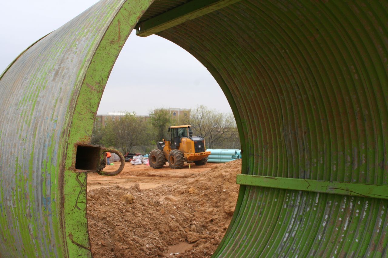 Construction site photographed through a curved corrugated opening