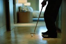 A man practicing putting in his study